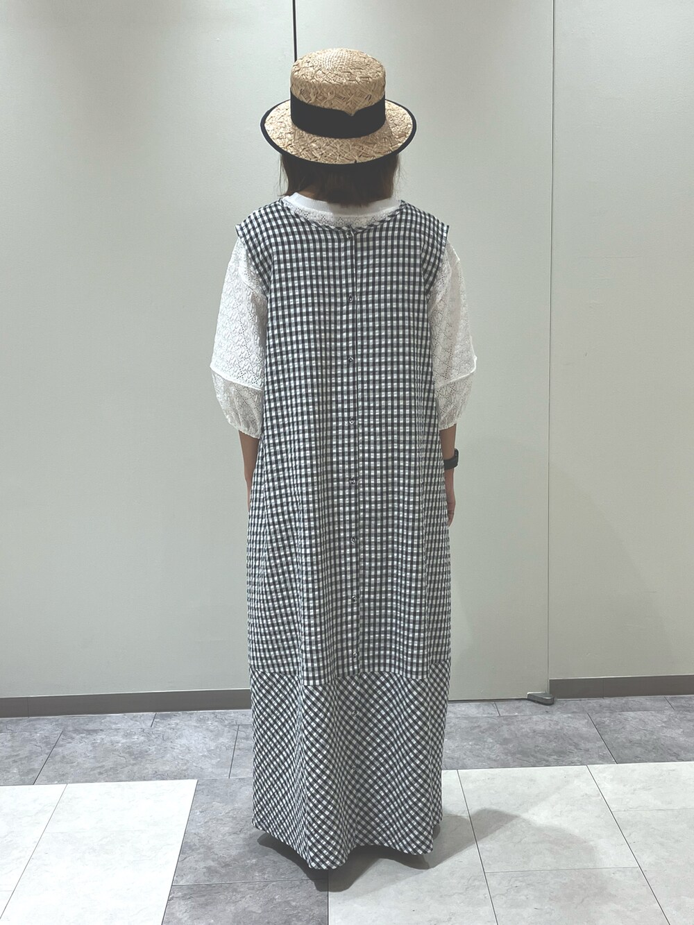 ブラック系のワンピース/ドレス、ホワイト系のトップス、ブラック系のサンダルを着用したレディースの夏コーディネートの3枚目の写真