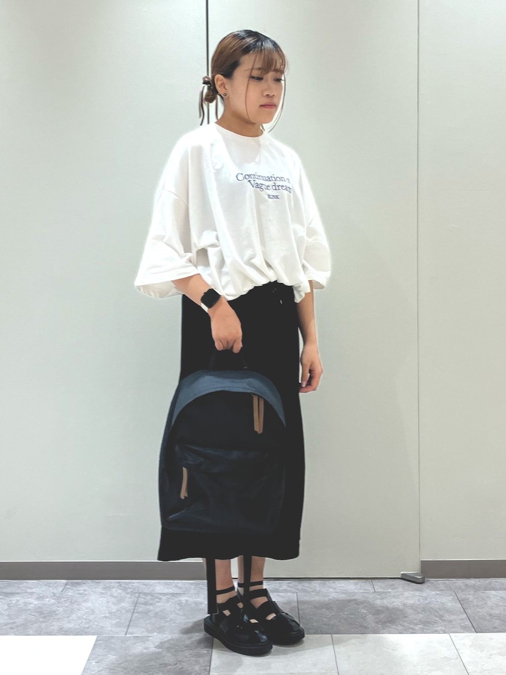 ホワイト系のサンダル、ブラック系のスカート、ホワイト系のTシャツ/カットソーを着用したレディースの春コーディネートの2枚目の写真