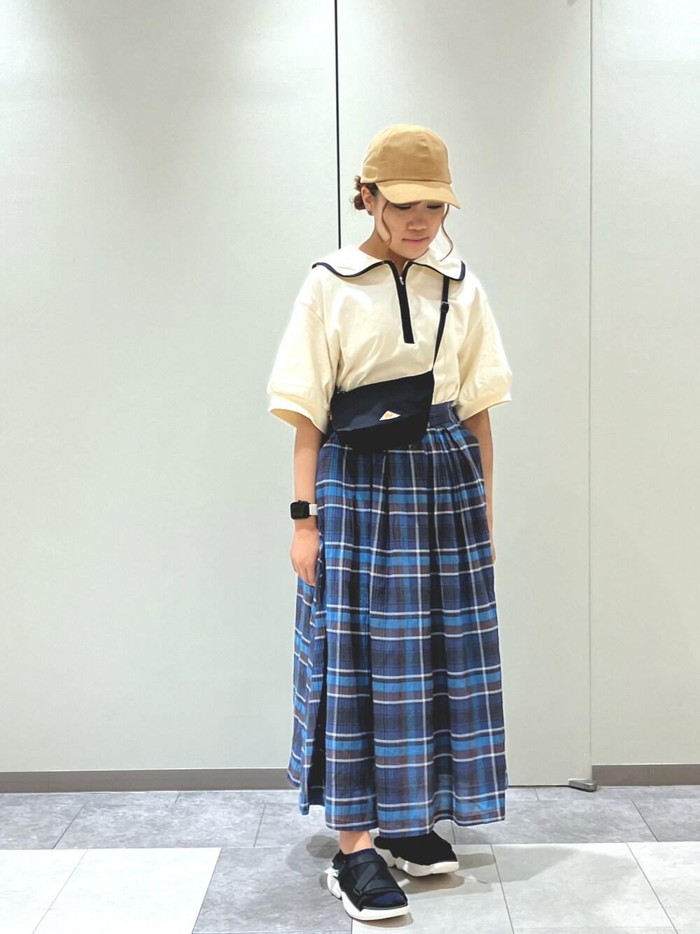 ブラック系のサンダル、ブルー系のスカート、ブラック系のハンドバッグを着用したレディースの春コーディネートの2枚目の写真