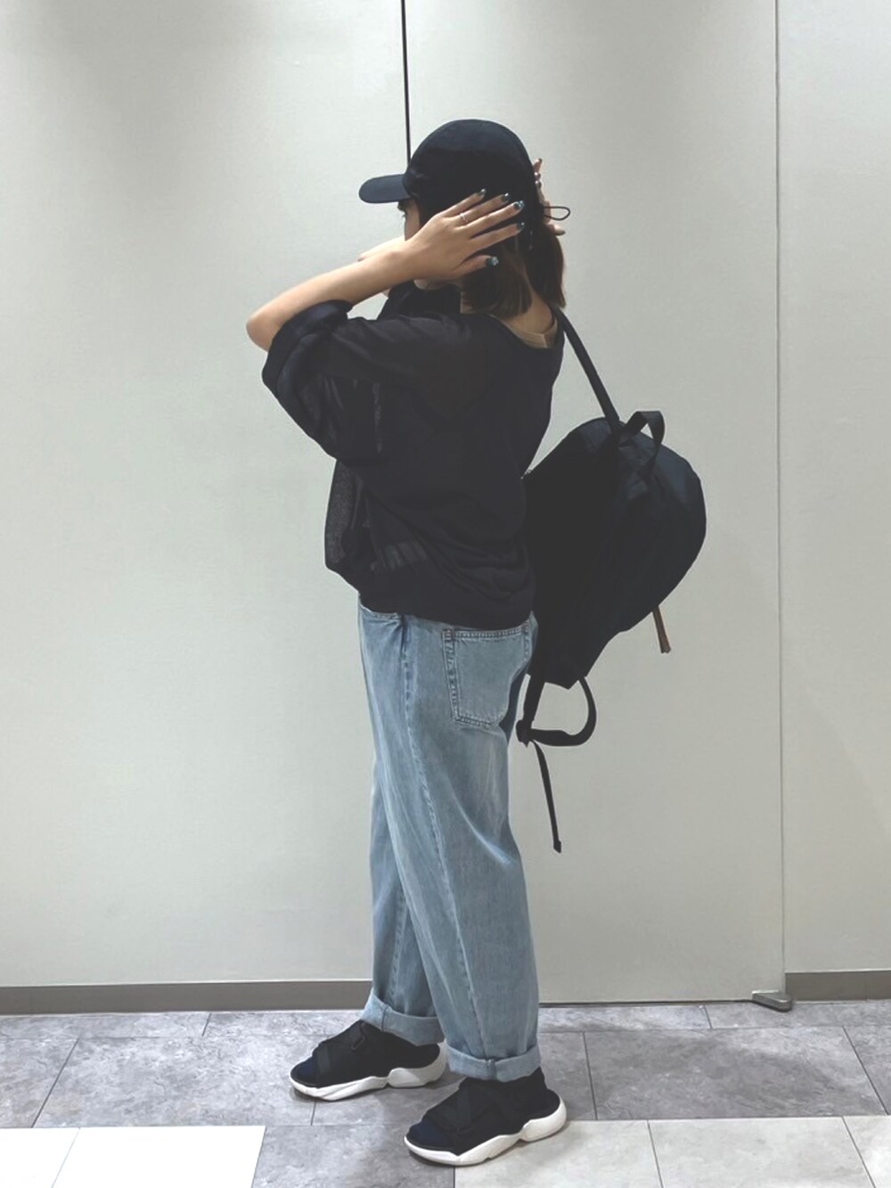 ブラック系のサンダル、ベージュ系のハンドバッグ、ブラック系のトップスを着用したレディースの春コーディネートの4枚目の写真