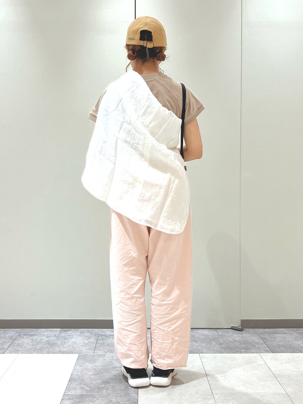 ブラウン系のパンツ、ブラック系のサンダル、ブラック系のハンドバッグを着用したレディースの春コーディネートの2枚目の写真