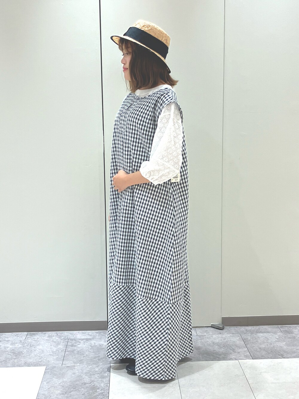 ブラック系のワンピース/ドレス、ホワイト系のトップス、ブラック系のサンダルを着用したレディースの夏コーディネートの2枚目の写真