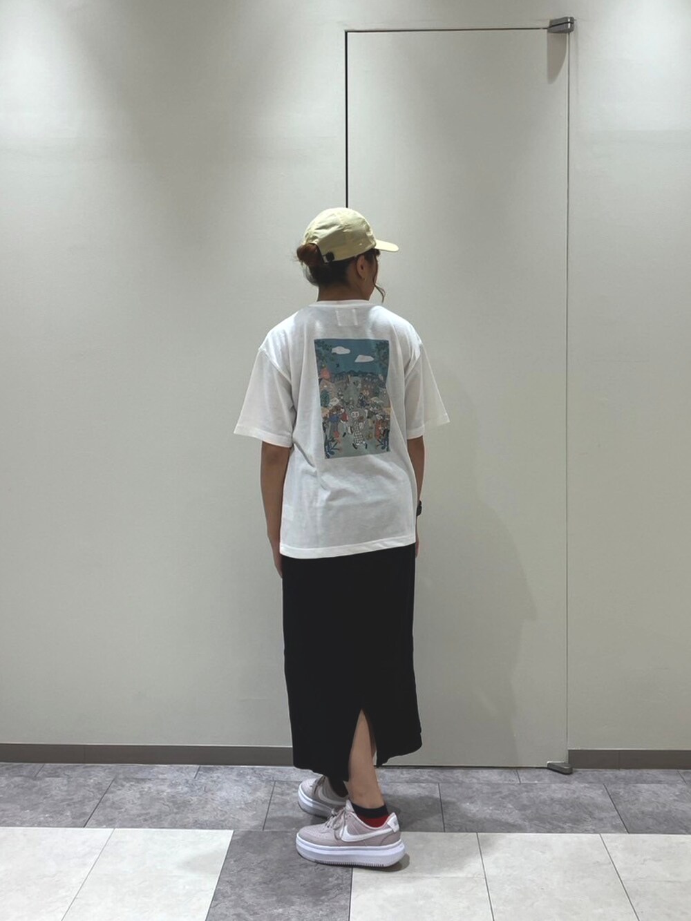 ピンク系のスニーカー、ブラック系のスカート、ホワイト系のトップスを着用したレディースの春コーディネートの4枚目の写真