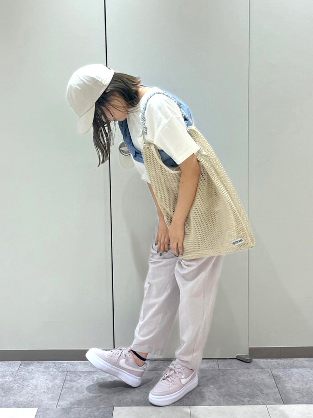 ブラック系のパンツ、ホワイト系のTシャツ/カットソー、オレンジ系のシャツ/ブラウスを着用したレディースの春コーディネートの2枚目の写真