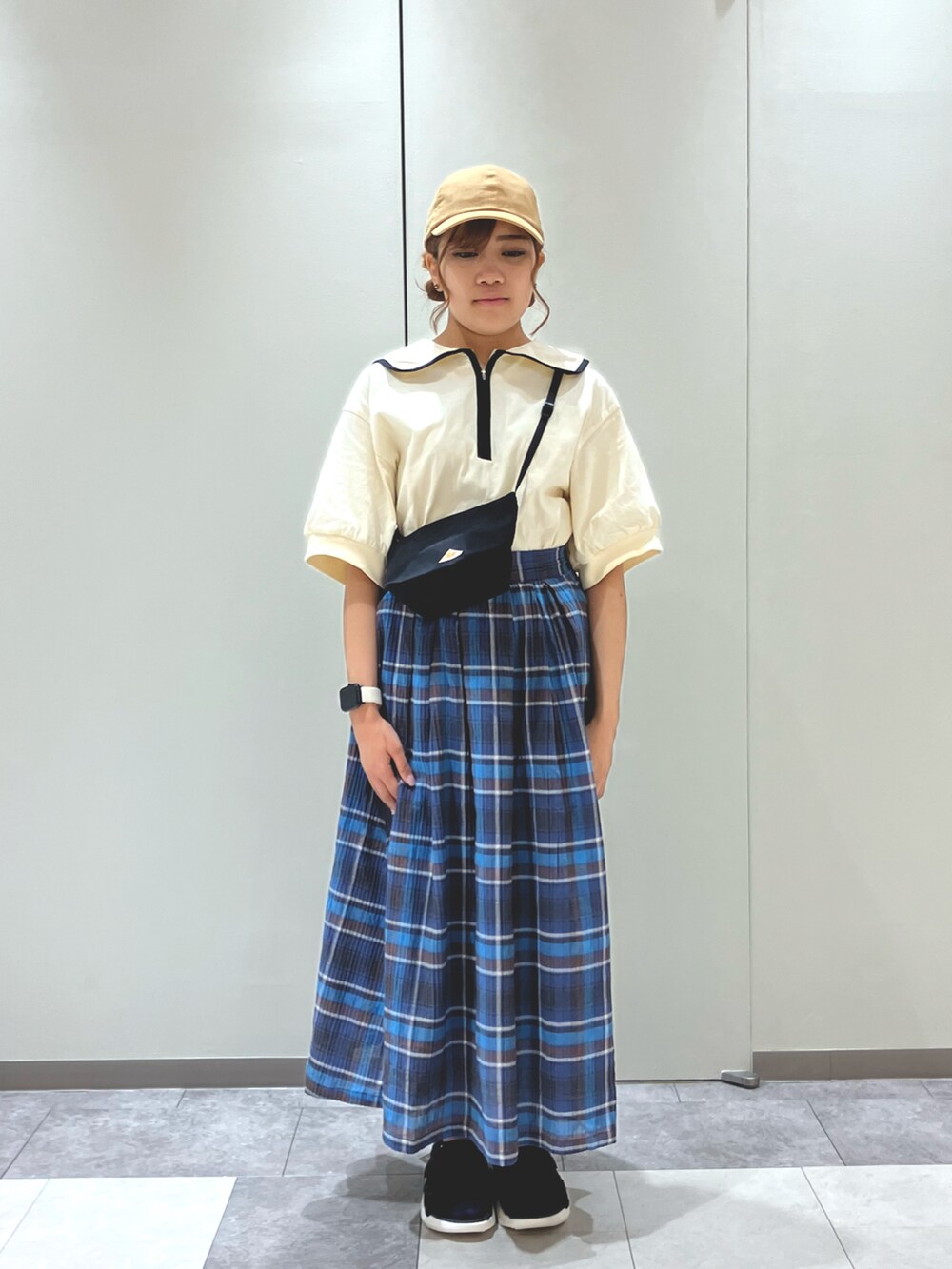 ブラック系のサンダル、ブルー系のスカート、ブラック系のハンドバッグを着用したレディースの春コーディネートの3枚目の写真