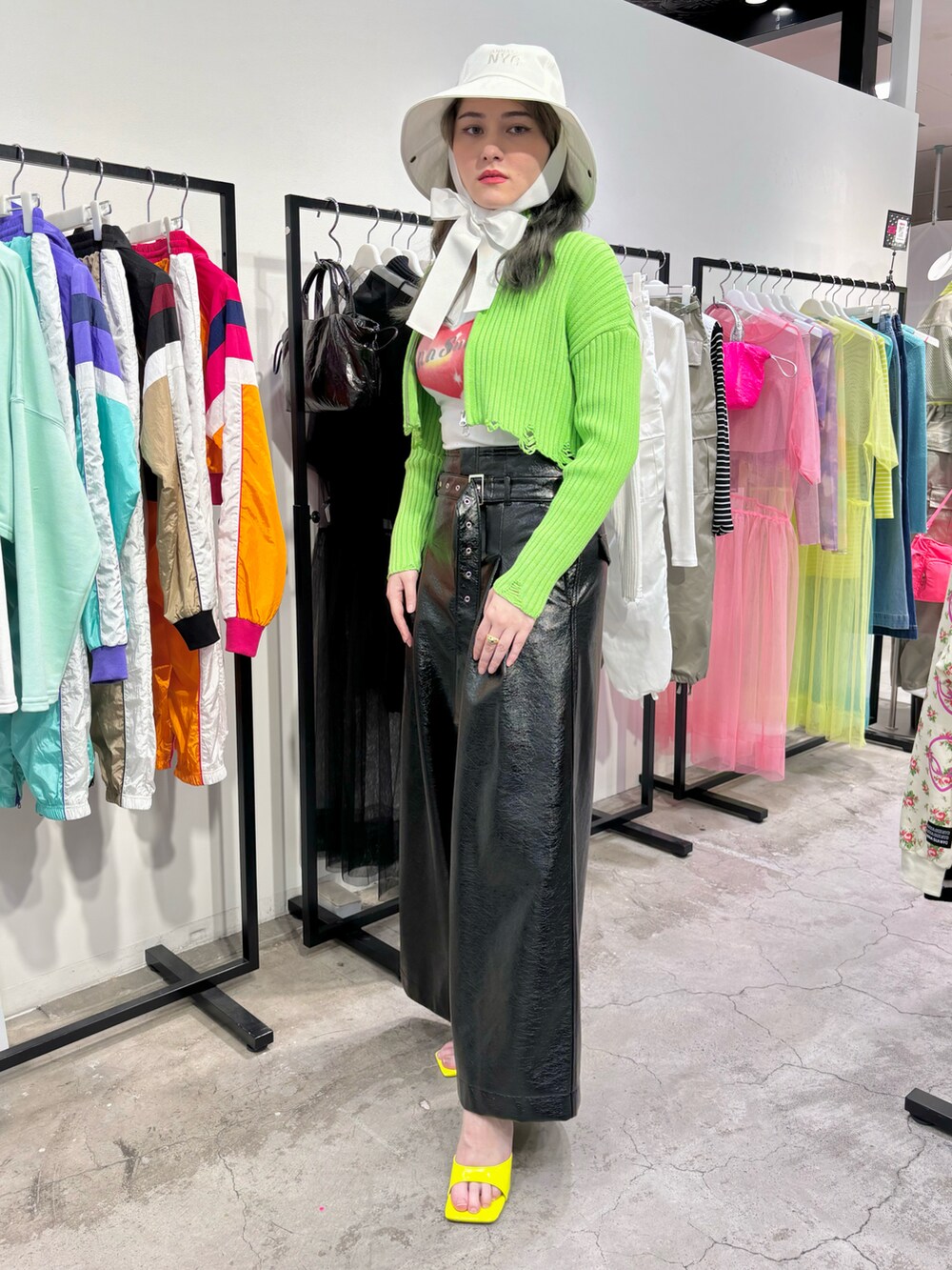 ブラック系のその他パンツ、ホワイト系のタンクトップ、グリーン系のカーディガン/ボレロを着用したレディースの春コーディネートの2枚目の写真