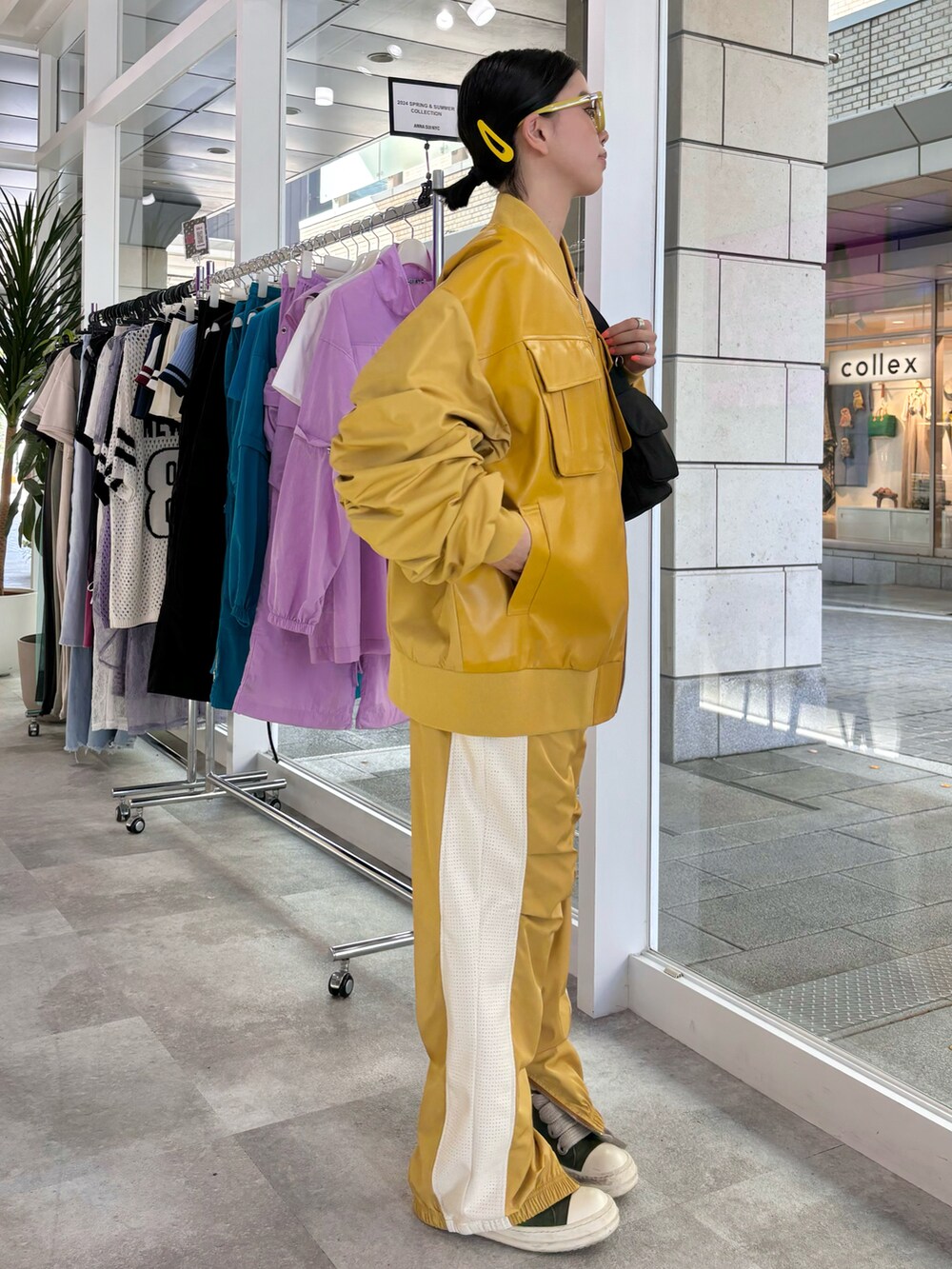 ブラック系のショルダーバッグ、イエロー系のその他アウター、イエロー系のその他パンツを着用したレディースの秋コーディネートの4枚目の写真