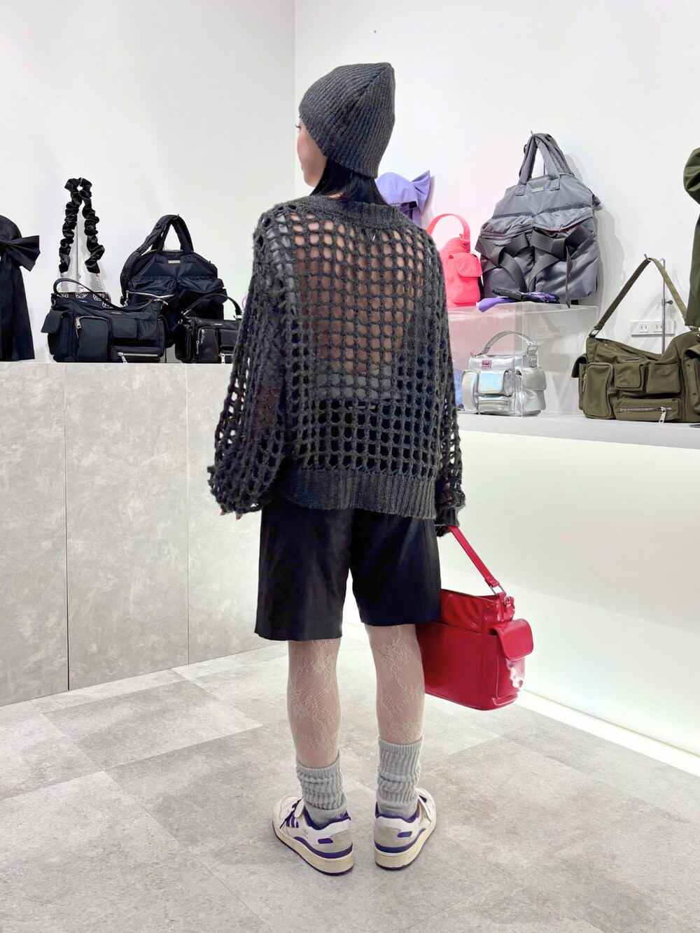 ブラック系のショルダーバッグ、ブラック系のニット/セーター、ブラック系のニットキャップ/ビーニーを着用したレディースの秋コーディネートの2枚目の写真