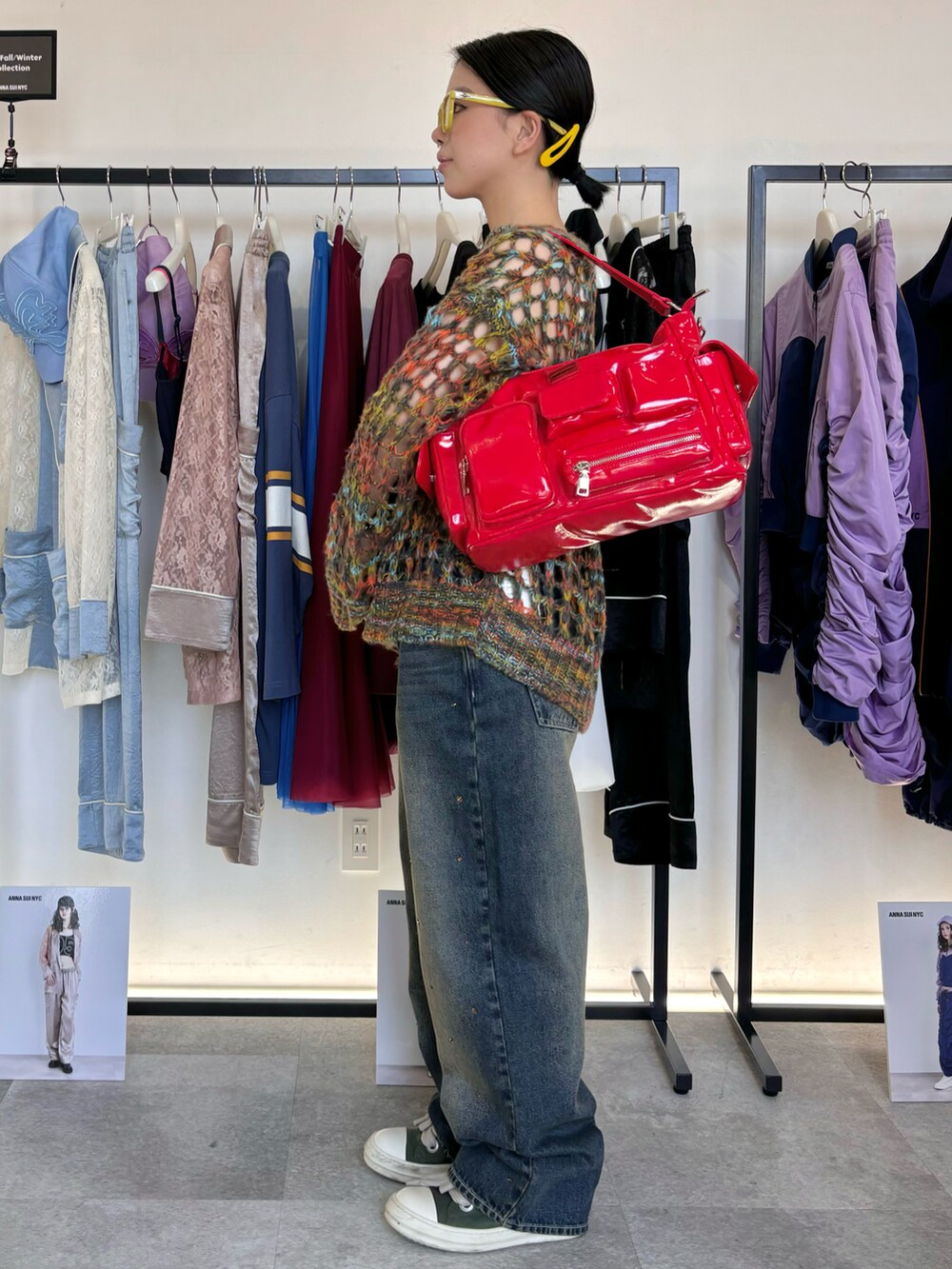 ブルー系のタンクトップ、ブルー系のデニムパンツ、オレンジ系のニット/セーターを着用したレディースの秋コーディネートの2枚目の写真