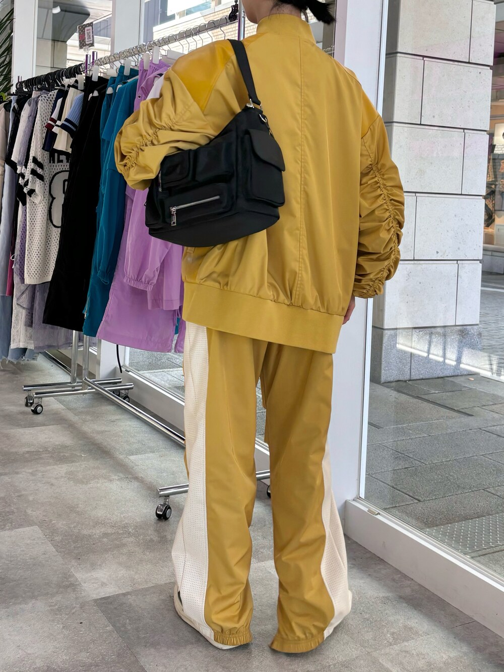 ブラック系のショルダーバッグ、イエロー系のその他アウター、イエロー系のその他パンツを着用したレディースの秋コーディネートの3枚目の写真