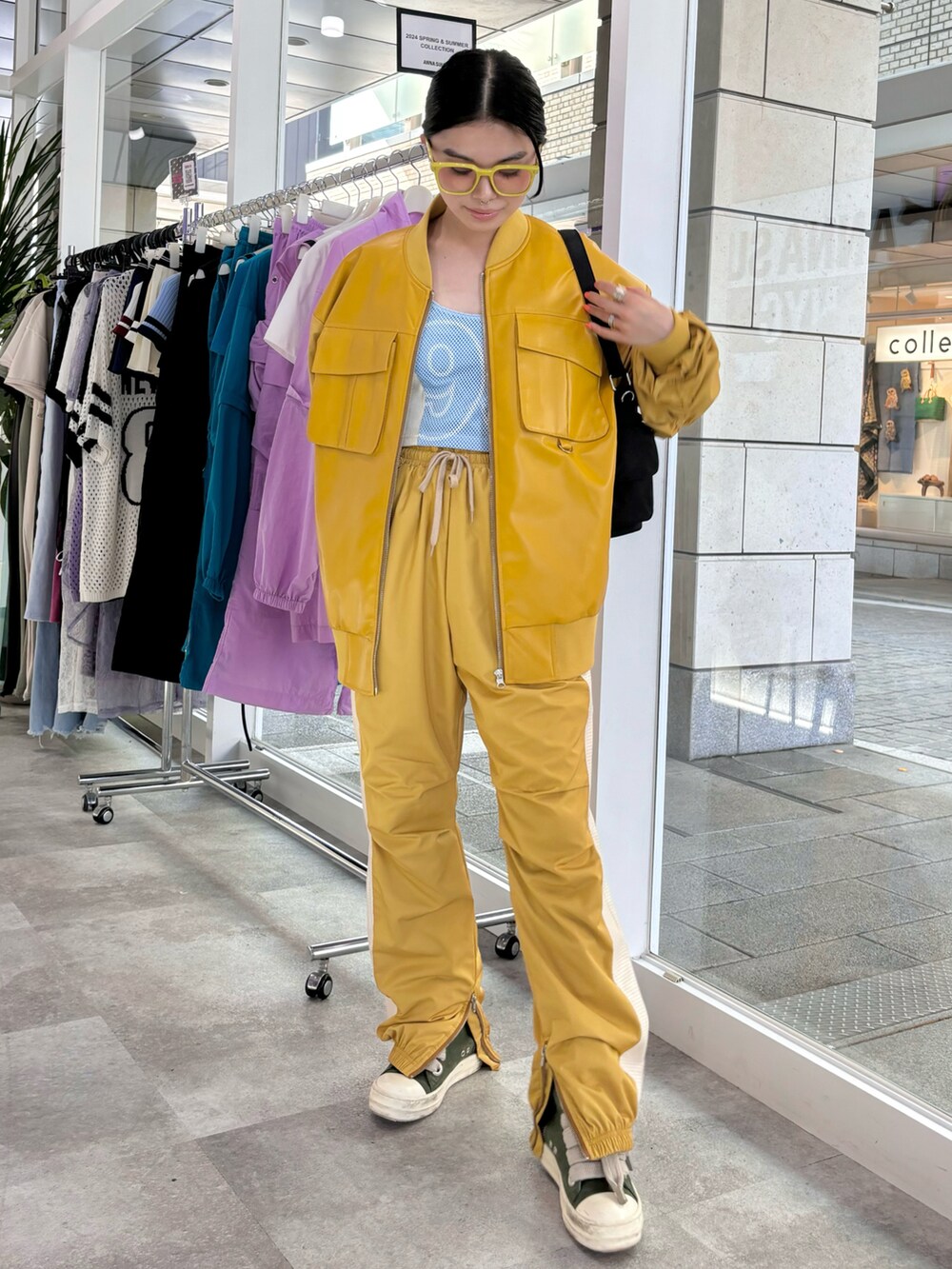 ブラック系のショルダーバッグ、イエロー系のその他アウター、イエロー系のその他パンツを着用したレディースの秋コーディネートの2枚目の写真