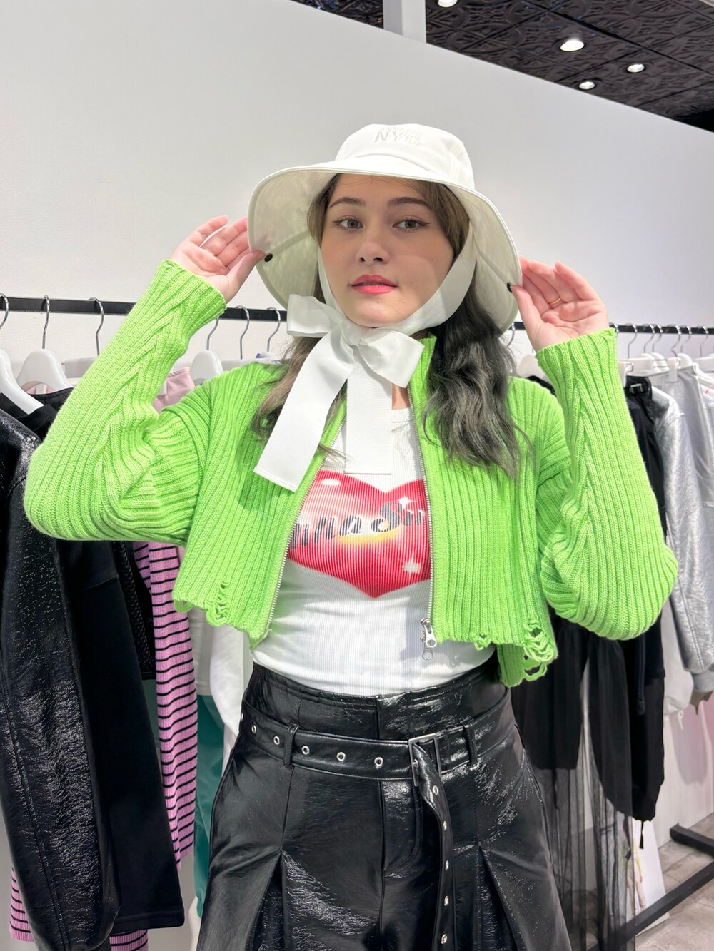 ブラック系のその他パンツ、ホワイト系のタンクトップ、グリーン系のカーディガン/ボレロを着用したレディースの春コーディネートの3枚目の写真