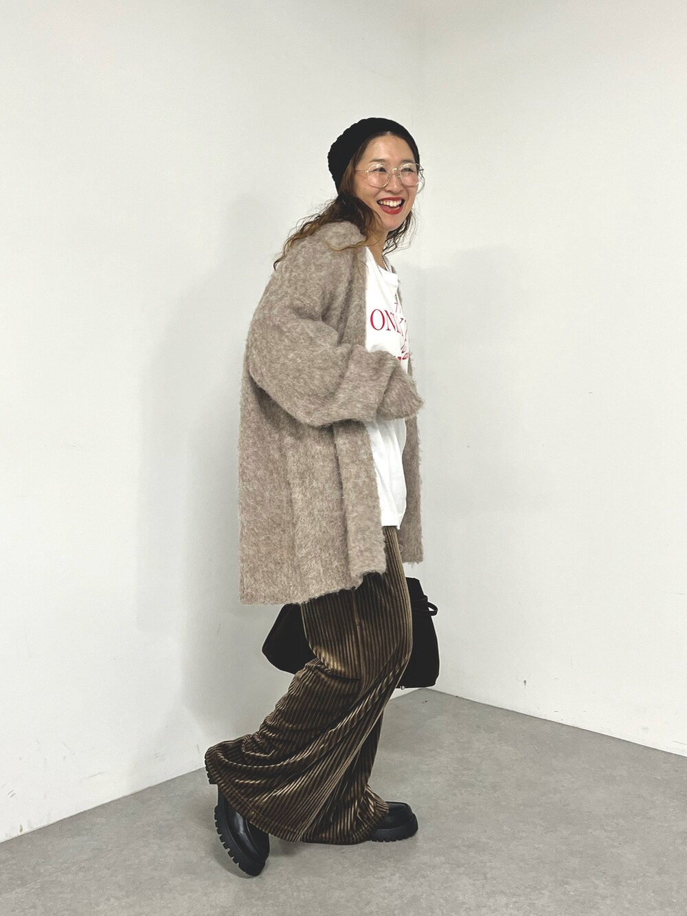 ブラウン系のパンツ、ベージュ系のカーディガン/ボレロを着用したレディースの秋コーディネートの3枚目の写真