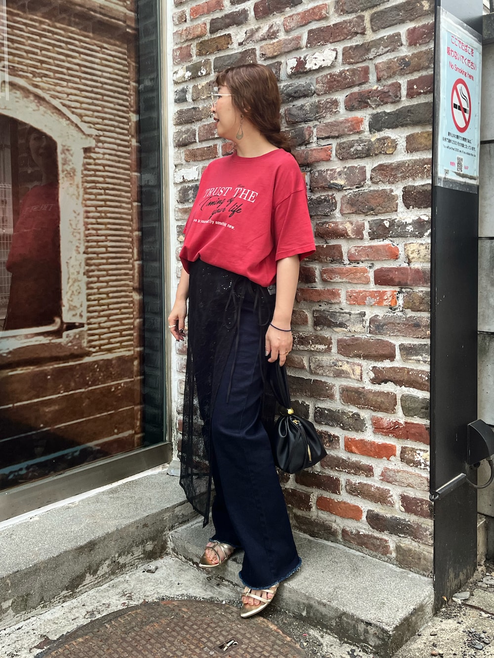 レッド系のTシャツ/カットソー、ブラック系のスカート、ブルー系のデニムパンツを着用したレディースの夏コーディネートの4枚目の写真