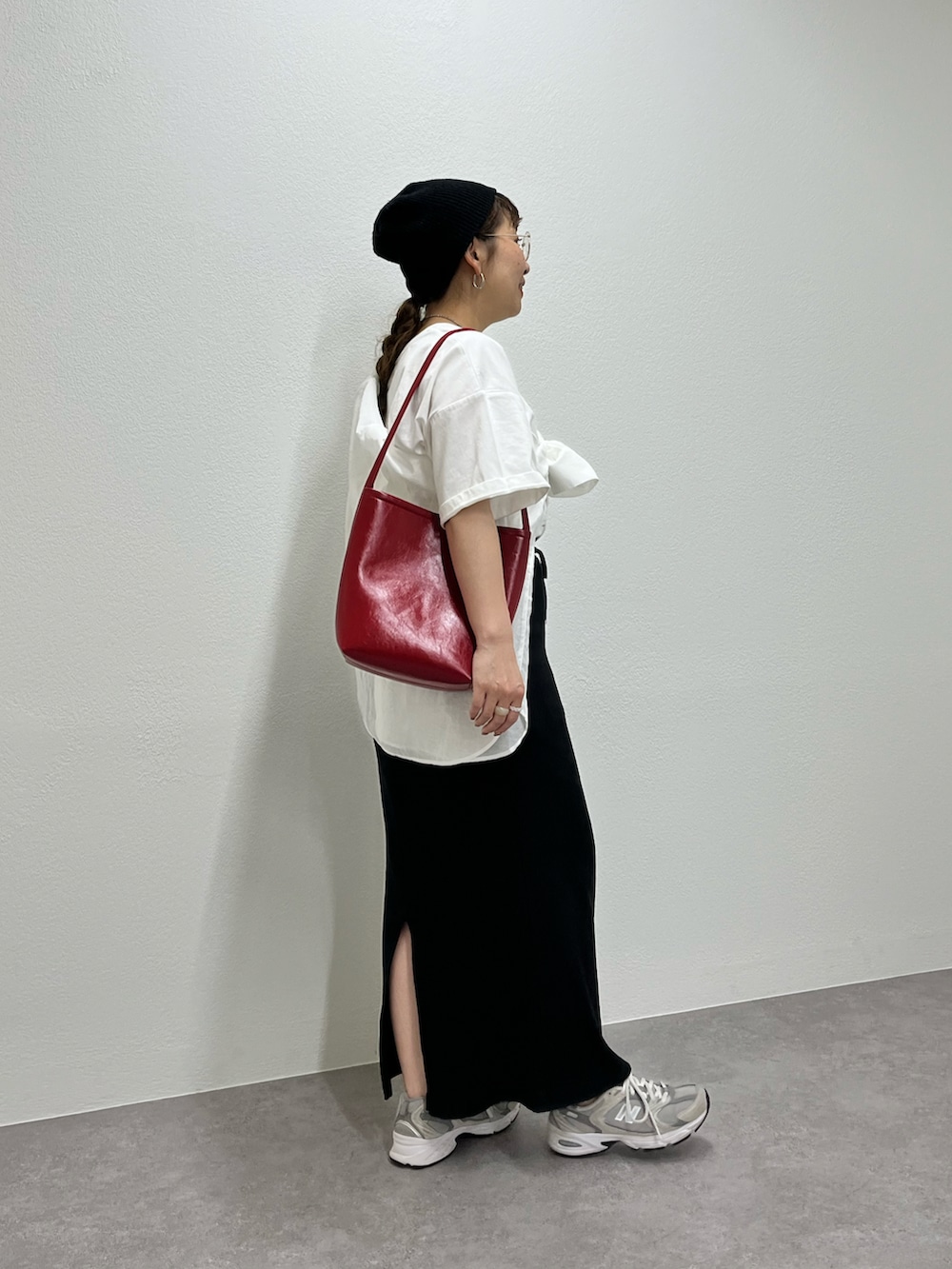 グレー系のスニーカー、ホワイト系のTシャツ/カットソー、ブラック系のスカートを着用したレディースの春コーディネートの2枚目の写真