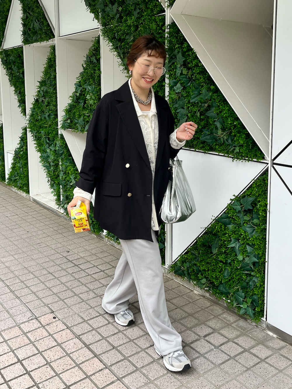 ブラック系のテーラードジャケット、グレー系のスウェットパンツ、グレー系のスニーカーを着用したレディースの春コーディネートの2枚目の写真