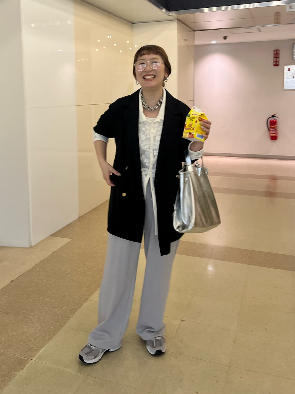 ブラック系のテーラードジャケット、グレー系のスウェットパンツ、グレー系のスニーカーを着用したレディースの春コーディネートの4枚目の写真