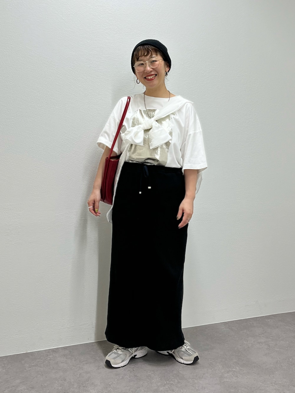 グレー系のスニーカー、ホワイト系のTシャツ/カットソー、ブラック系のスカートを着用したレディースの春コーディネートの5枚目の写真