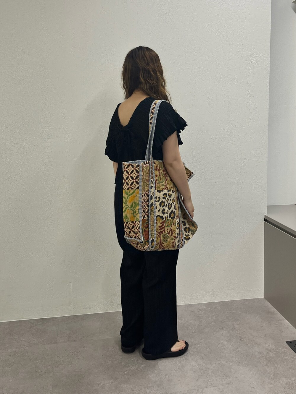 ベージュ系のショルダーバッグ、ブラック系のワンピースを着用したレディースの夏コーディネートの4枚目の写真