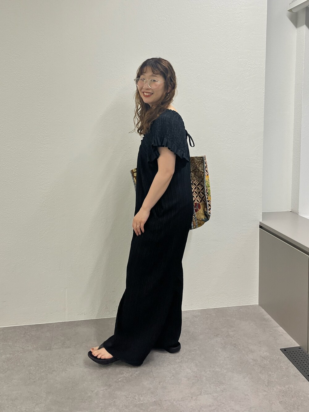 ベージュ系のショルダーバッグ、ブラック系のワンピースを着用したレディースの夏コーディネートの3枚目の写真