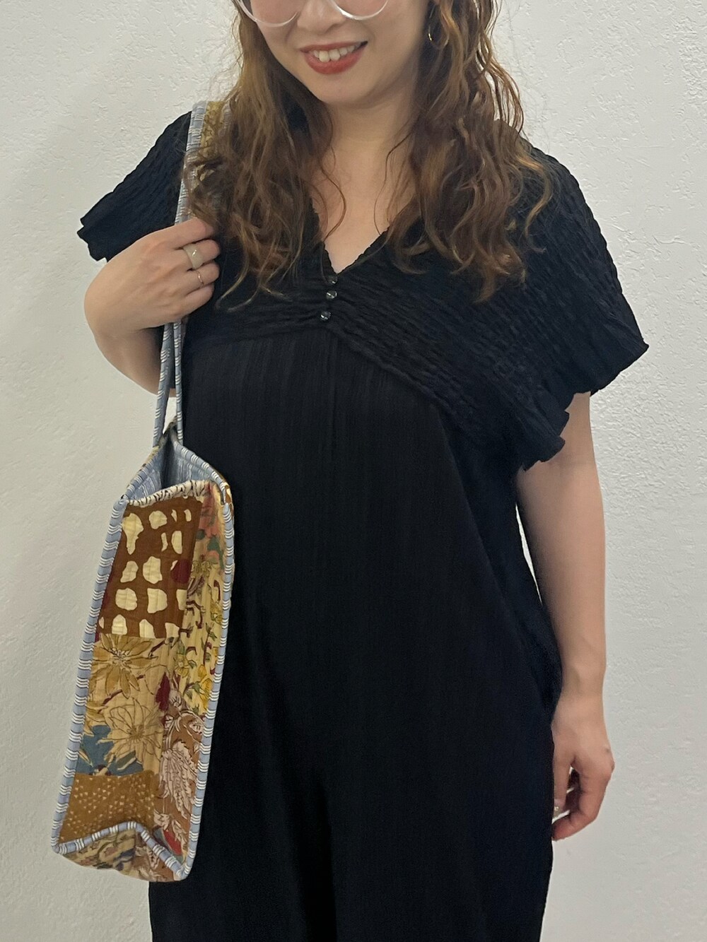 ベージュ系のショルダーバッグ、ブラック系のワンピースを着用したレディースの夏コーディネートの5枚目の写真