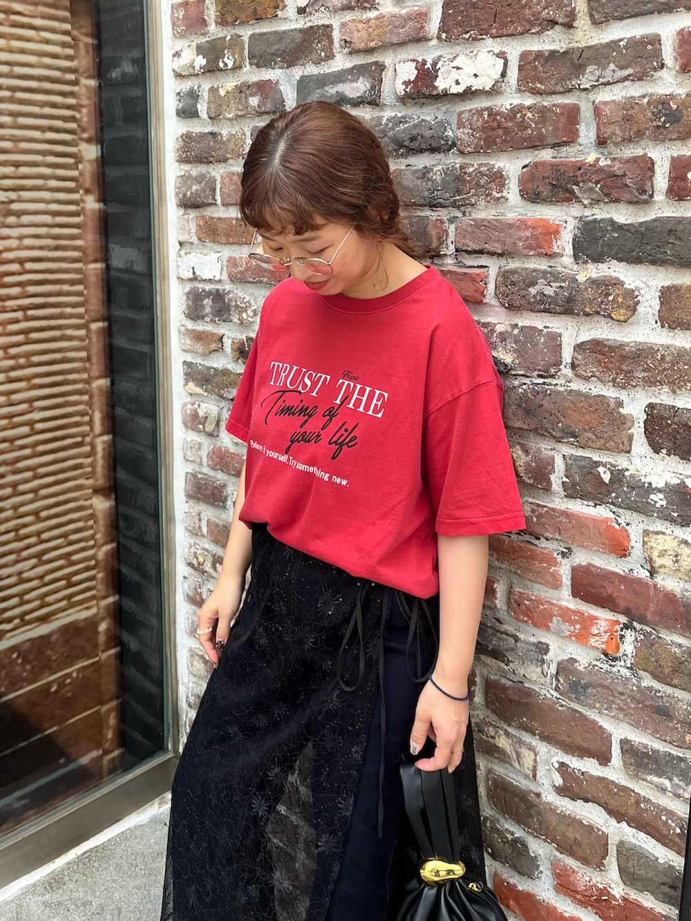 レッド系のTシャツ/カットソー、ブラック系のスカート、ブルー系のデニムパンツを着用したレディースの夏コーディネートの3枚目の写真