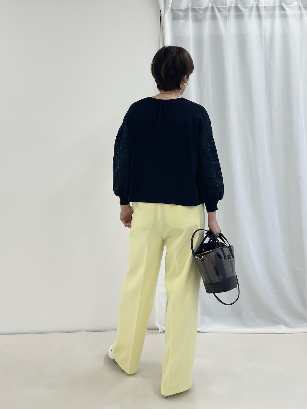 ブルー系のカーディガン/ボレロ、イエロー系のその他パンツ、ブラック系のかごバッグを着用したレディースの春コーディネートの3枚目の写真