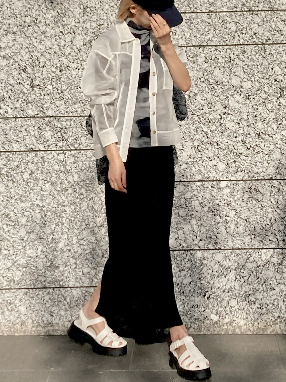 グリーン系のその他トップス、ブラック系のスカート、ホワイト系のサンダルを着用したレディースの春コーディネートの2枚目の写真