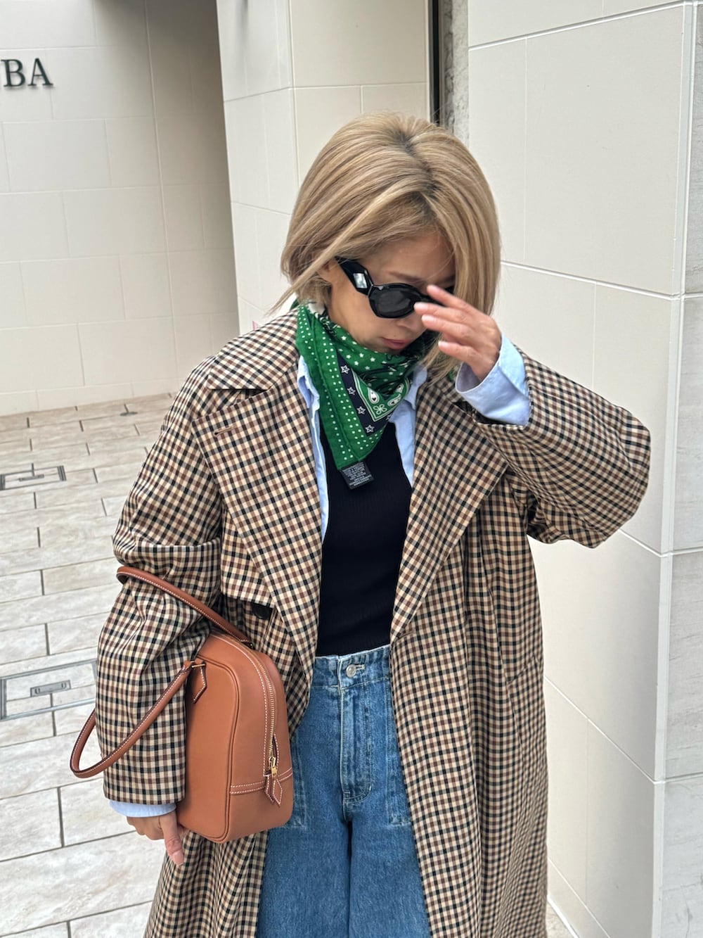 ブラウン系のジャケット/アウター、ブルー系のデニムパンツ、ブラウン系のバッグを着用したレディースの秋コーディネートの4枚目の写真