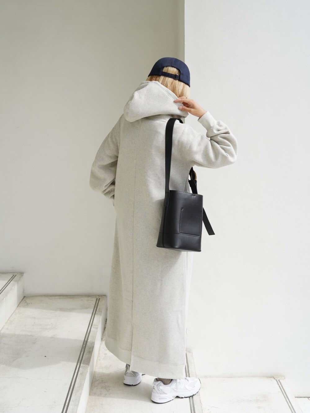 ブラック系のバッグ、ホワイト系のスニーカー、ベージュ系のワンピースを着用したレディースの秋コーディネートの5枚目の写真