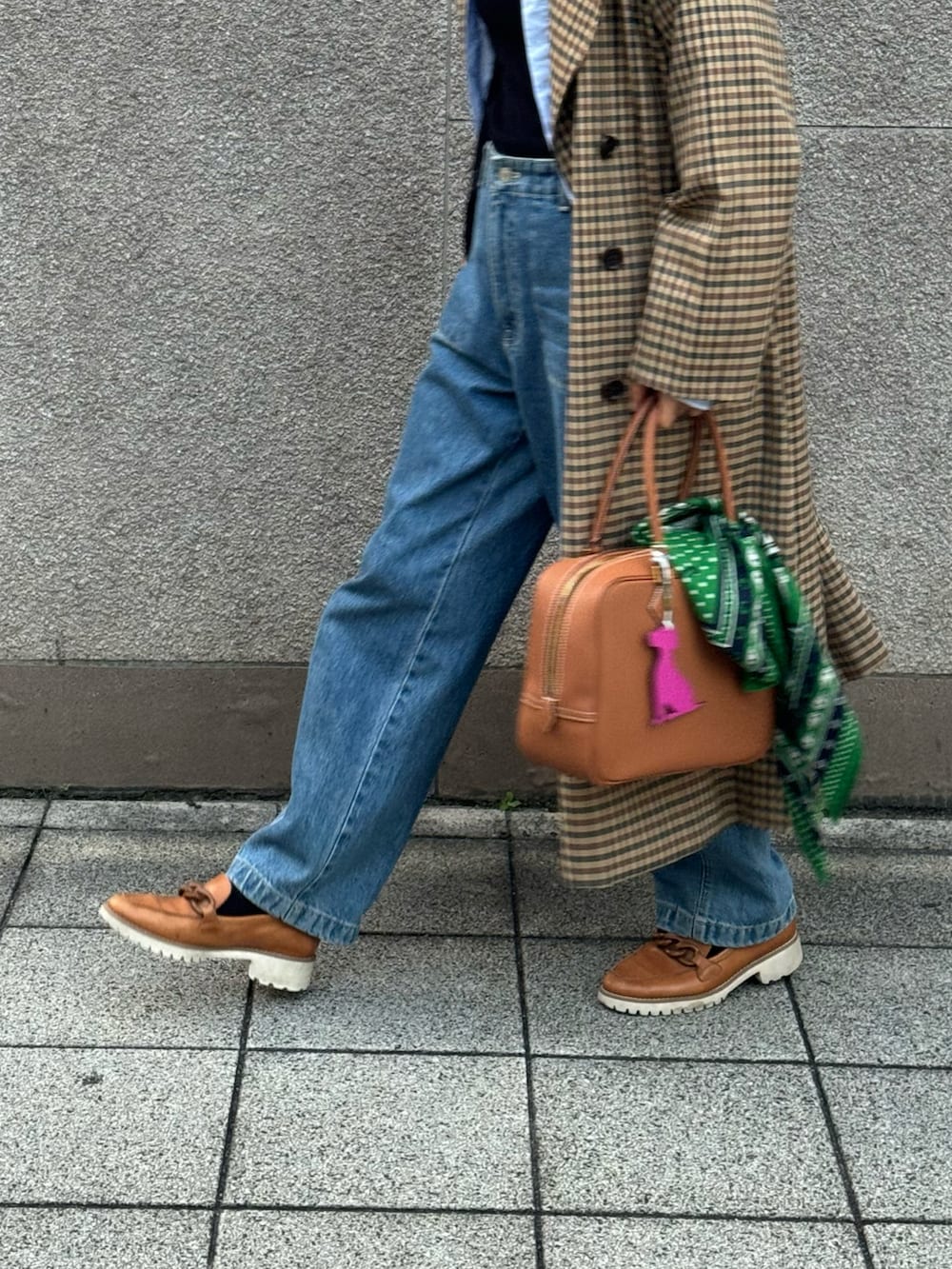 ブラウン系のジャケット/アウター、ブルー系のデニムパンツ、ブラウン系のバッグを着用したレディースの秋コーディネートの2枚目の写真