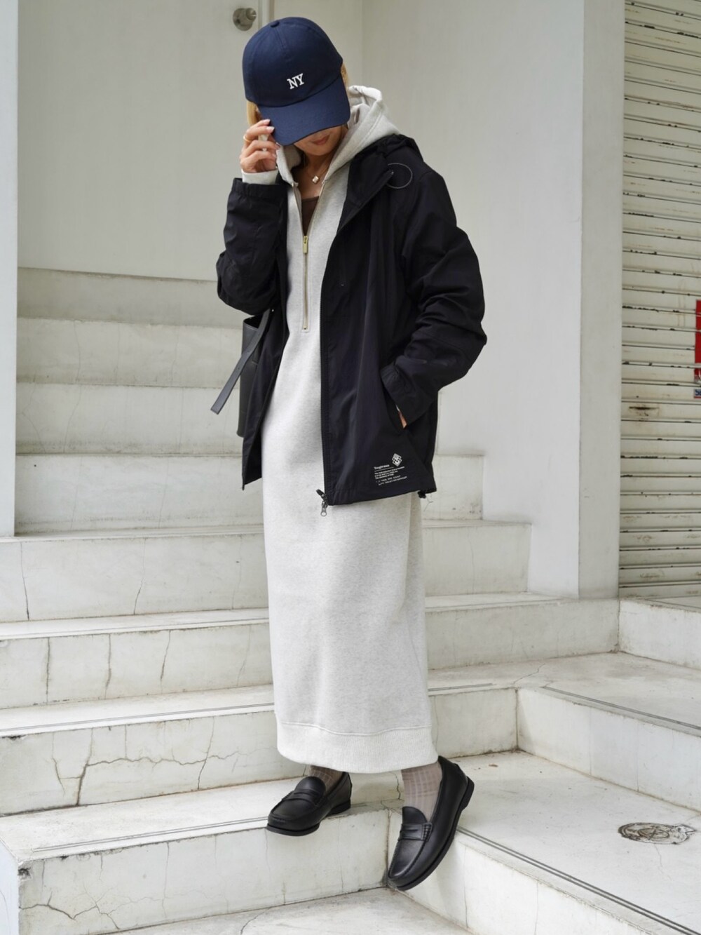 ブラック系のバッグ、ホワイト系のスニーカー、ベージュ系のワンピースを着用したレディースの秋コーディネートの3枚目の写真