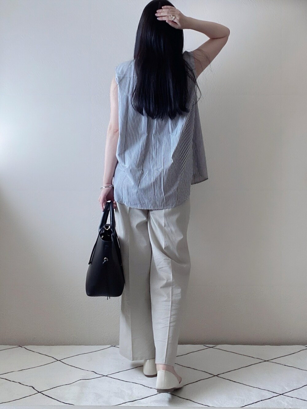 ブラック系のシャツ/ブラウス、ベージュ系のパンツ、ブラック系のトートバッグを着用したレディースの夏コーディネートの3枚目の写真