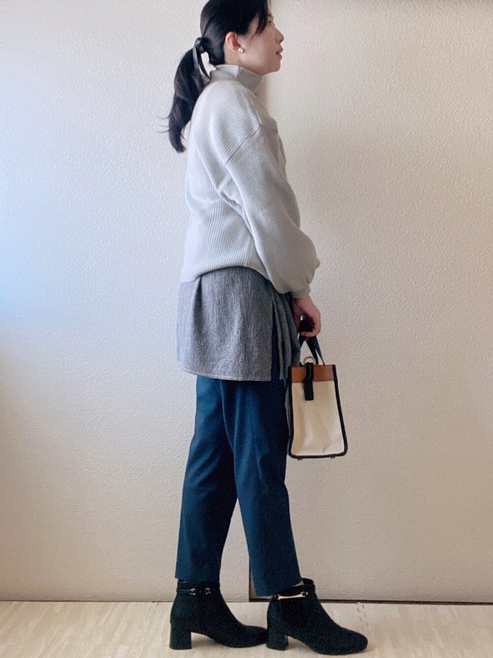 ブラック系のブーツ、ホワイト系のトートバッグ、グレー系のニット/セーターを着用したレディースの秋コーディネートの2枚目の写真