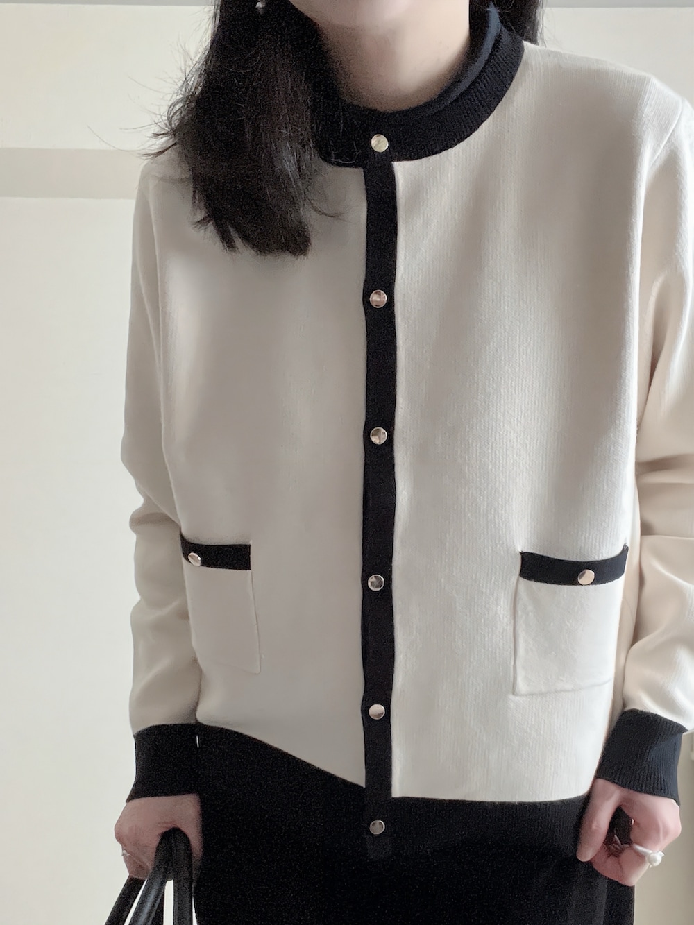 ブラック系のショルダーバッグ、ベージュ系のカーディガン/ボレロ、ブラック系のスラックスを着用したレディースの冬コーディネートの3枚目の写真