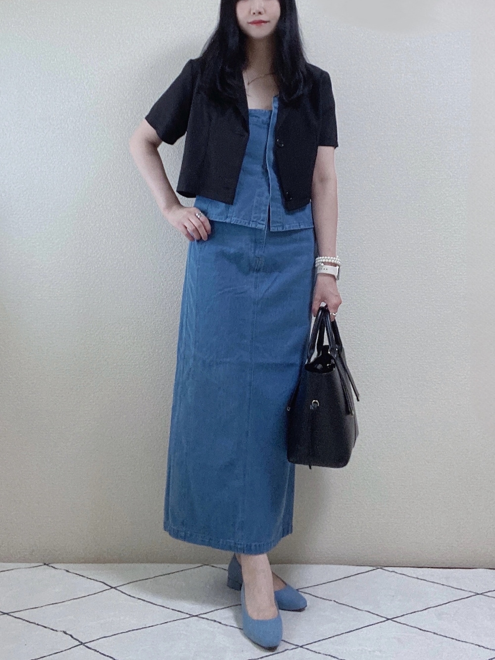 ブラック系のセットアップ、ブルー系のスカート、ブラック系のトートバッグを着用したレディースの秋コーディネートの2枚目の写真