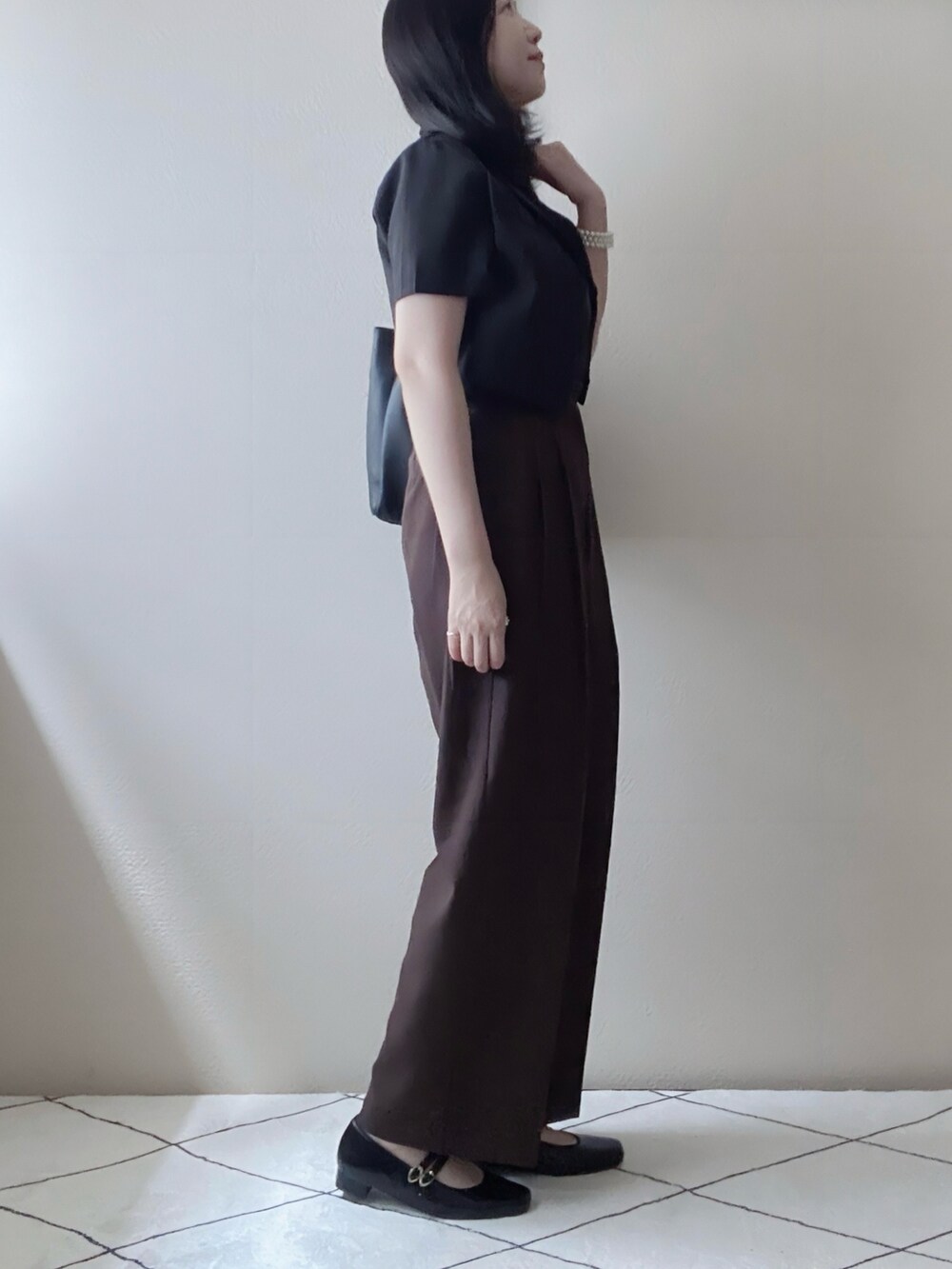 ブラック系のセットアップ、ブラック系のキャミソール、ブラウン系のパンツを着用したレディースの秋コーディネートの2枚目の写真