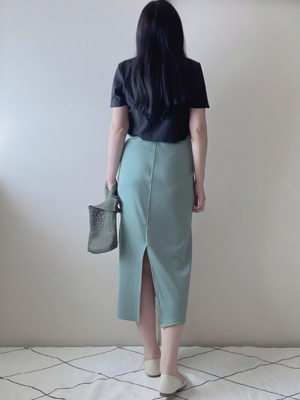 ブラック系のセットアップ、グリーン系のワンピース/ドレス、グリーン系のバッグを着用したレディースの夏コーディネートの2枚目の写真