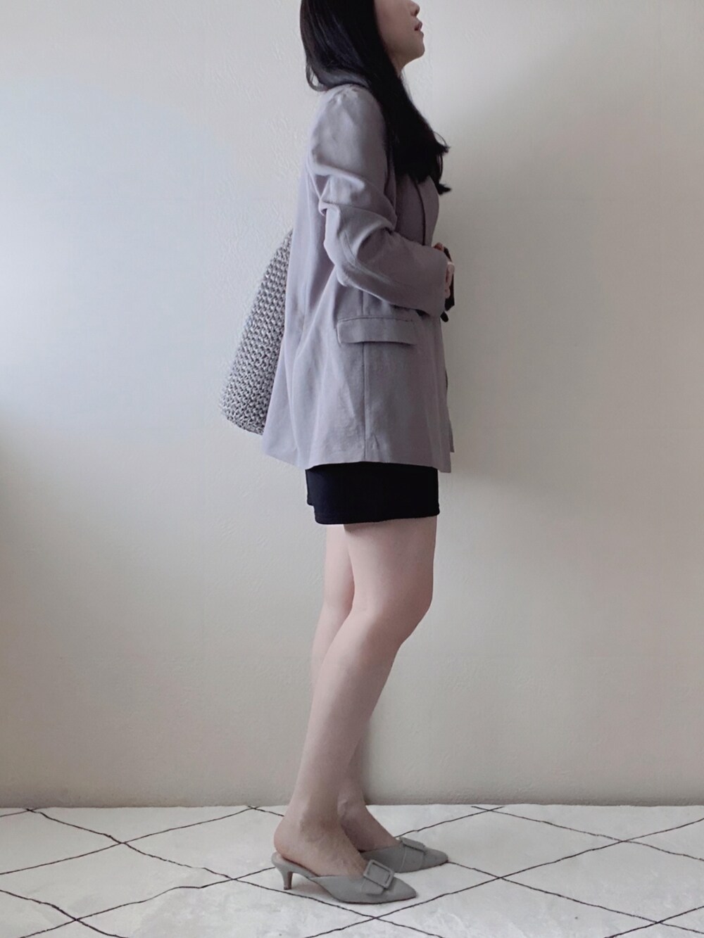 ブラック系のパンツ、シルバー系のボストンバッグ、グレー系のサンダルを着用したレディースの春コーディネートの3枚目の写真