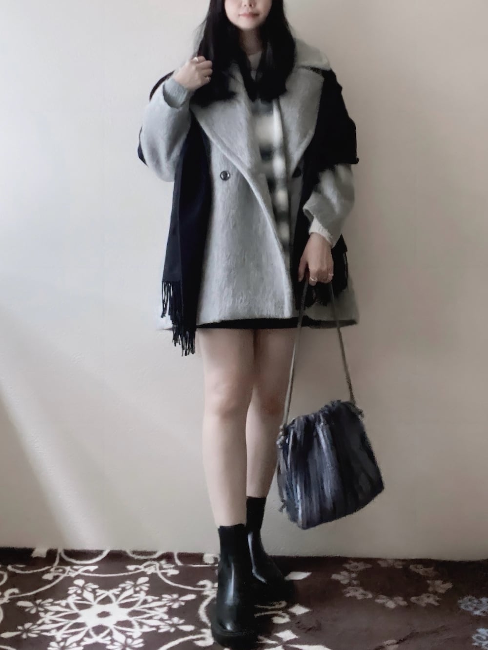 ブラック系のニット/セーター、ブラック系のワンピース/ドレス、グレー系のピーコートを着用したレディースの冬コーディネートの2枚目の写真