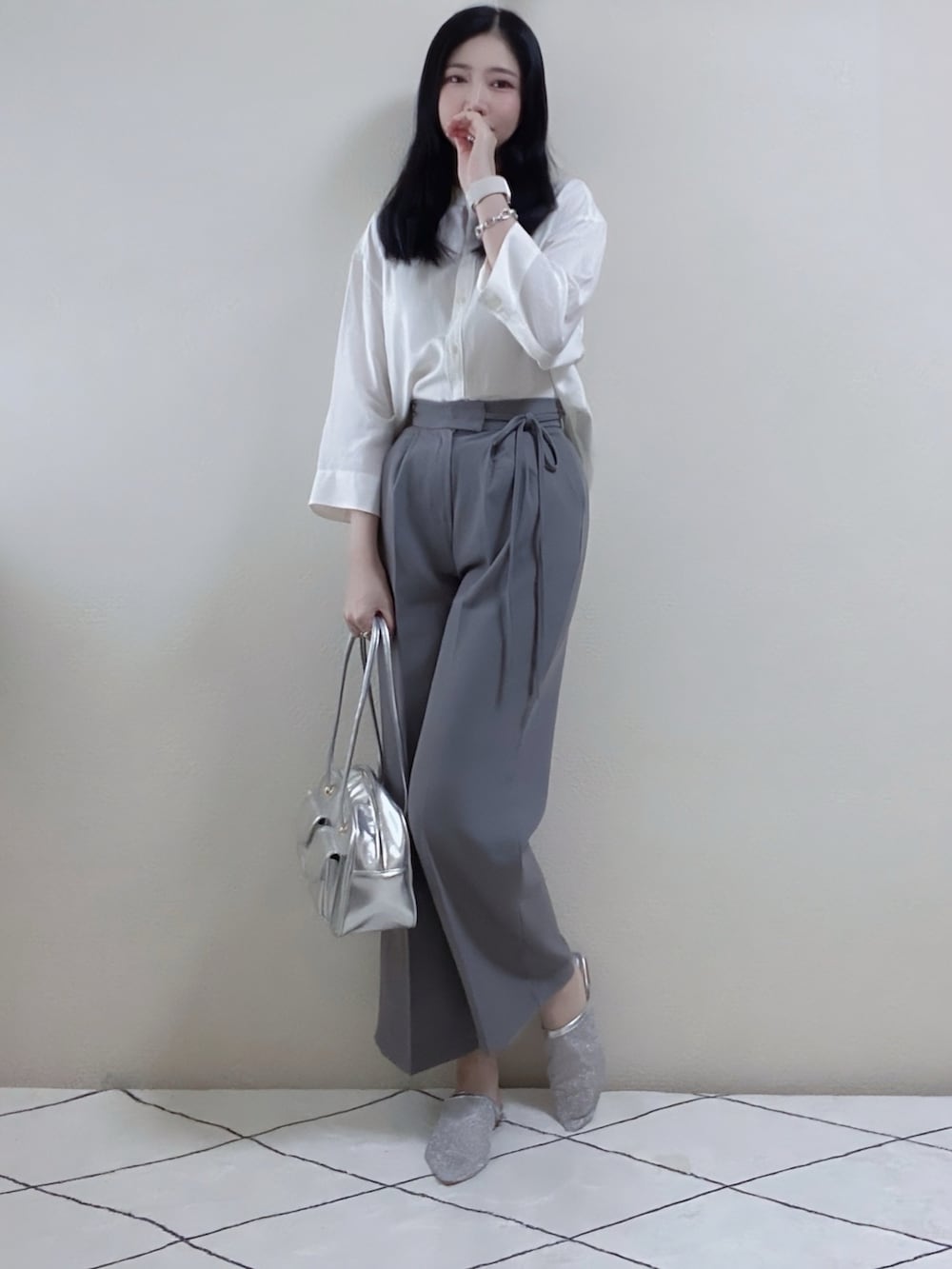 グレー系のスラックス、シルバー系のボストンバッグ、ホワイト系のシャツ/ブラウスを着用したレディースの秋コーディネートの2枚目の写真