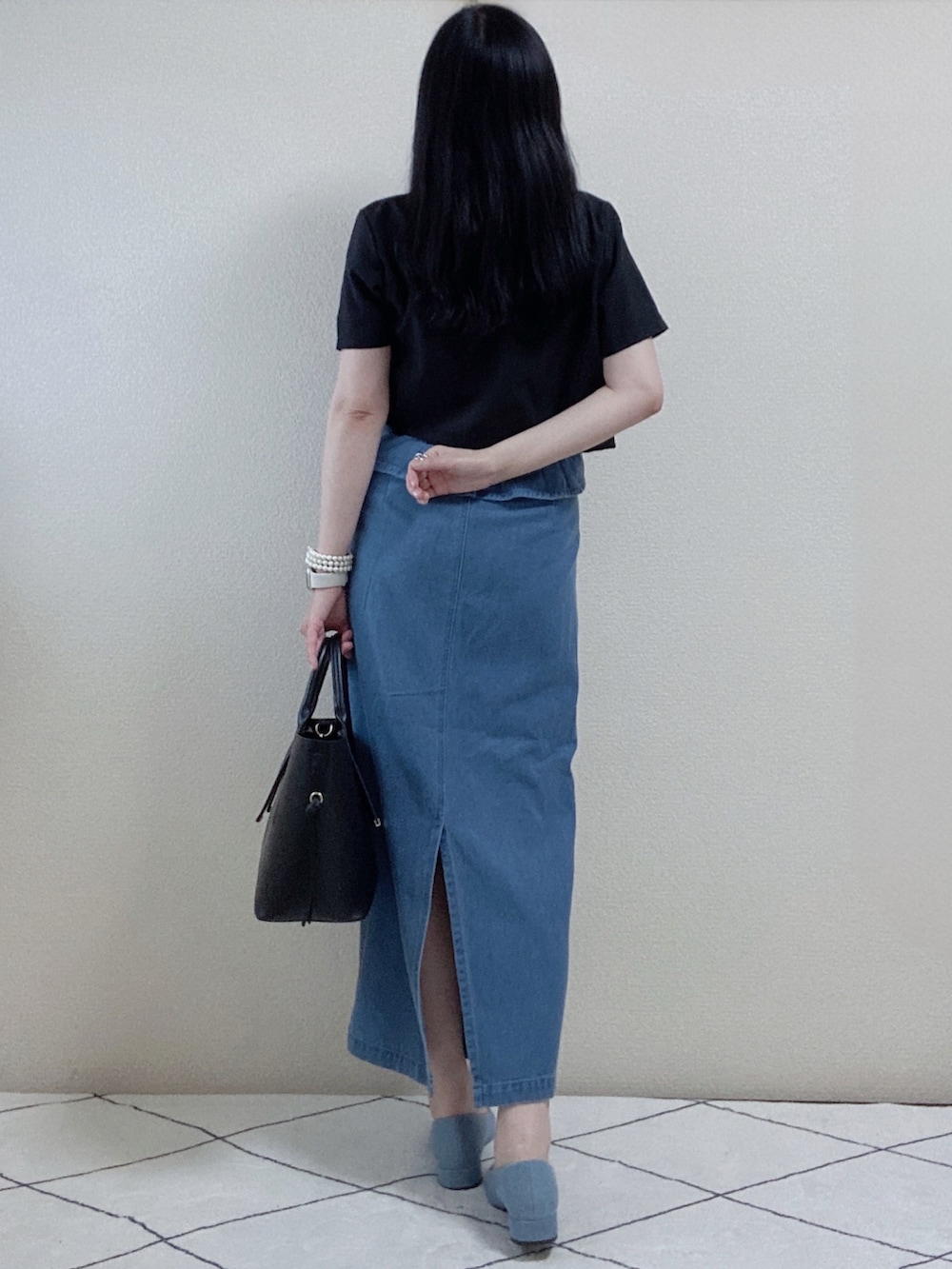 ブラック系のセットアップ、ブルー系のスカート、ブラック系のトートバッグを着用したレディースの秋コーディネートの3枚目の写真