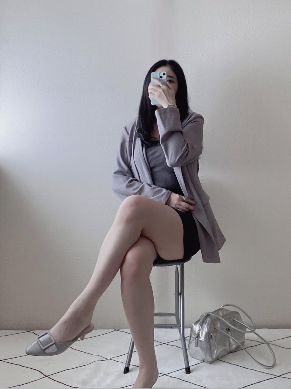 ブラック系のパンツ、シルバー系のボストンバッグ、グレー系のサンダルを着用したレディースの春コーディネートの2枚目の写真