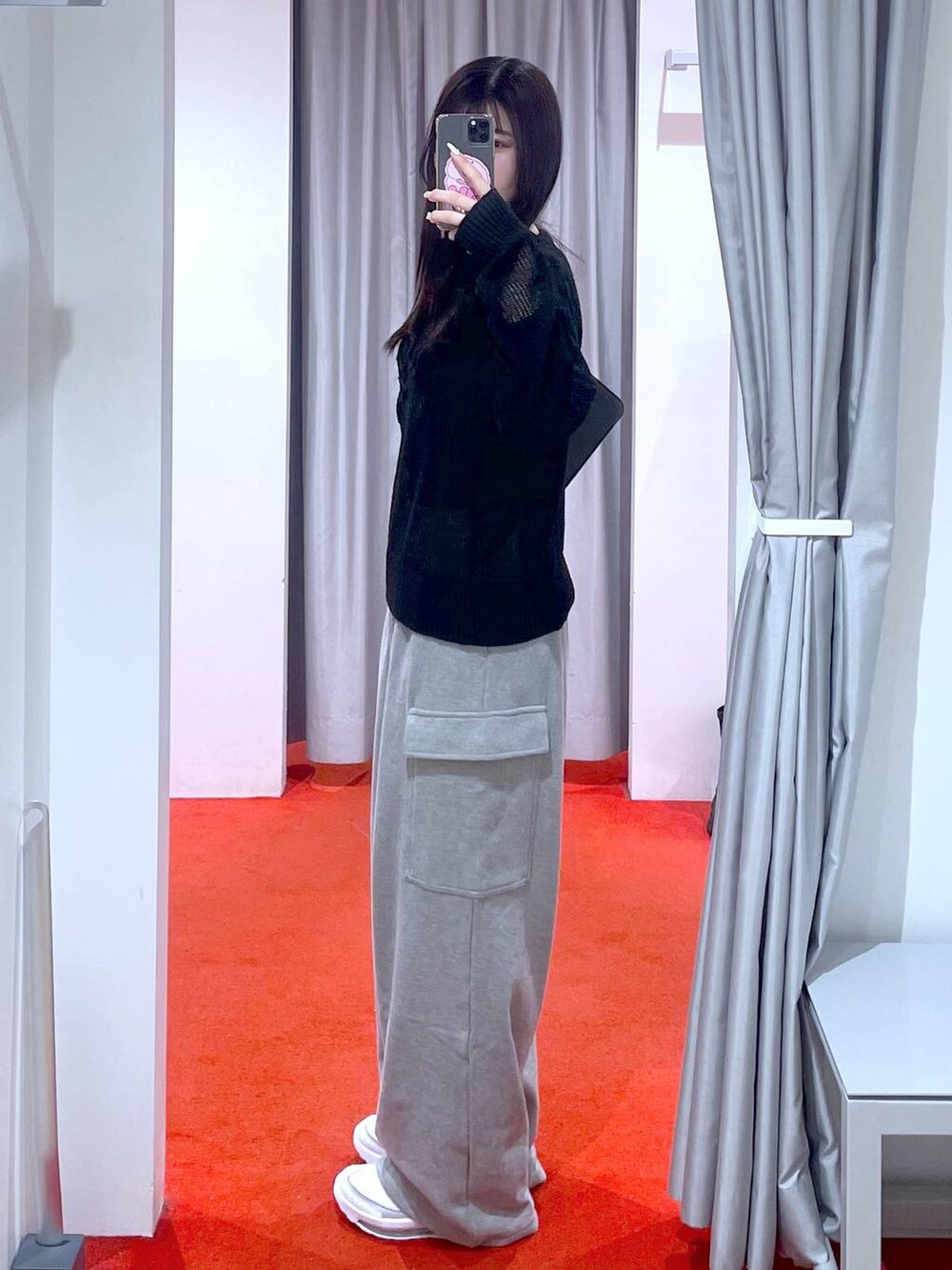 ブラック系のショルダーバッグ、ホワイト系のスニーカー、グレー系のカーゴパンツを着用したレディースの冬コーディネートの2枚目の写真