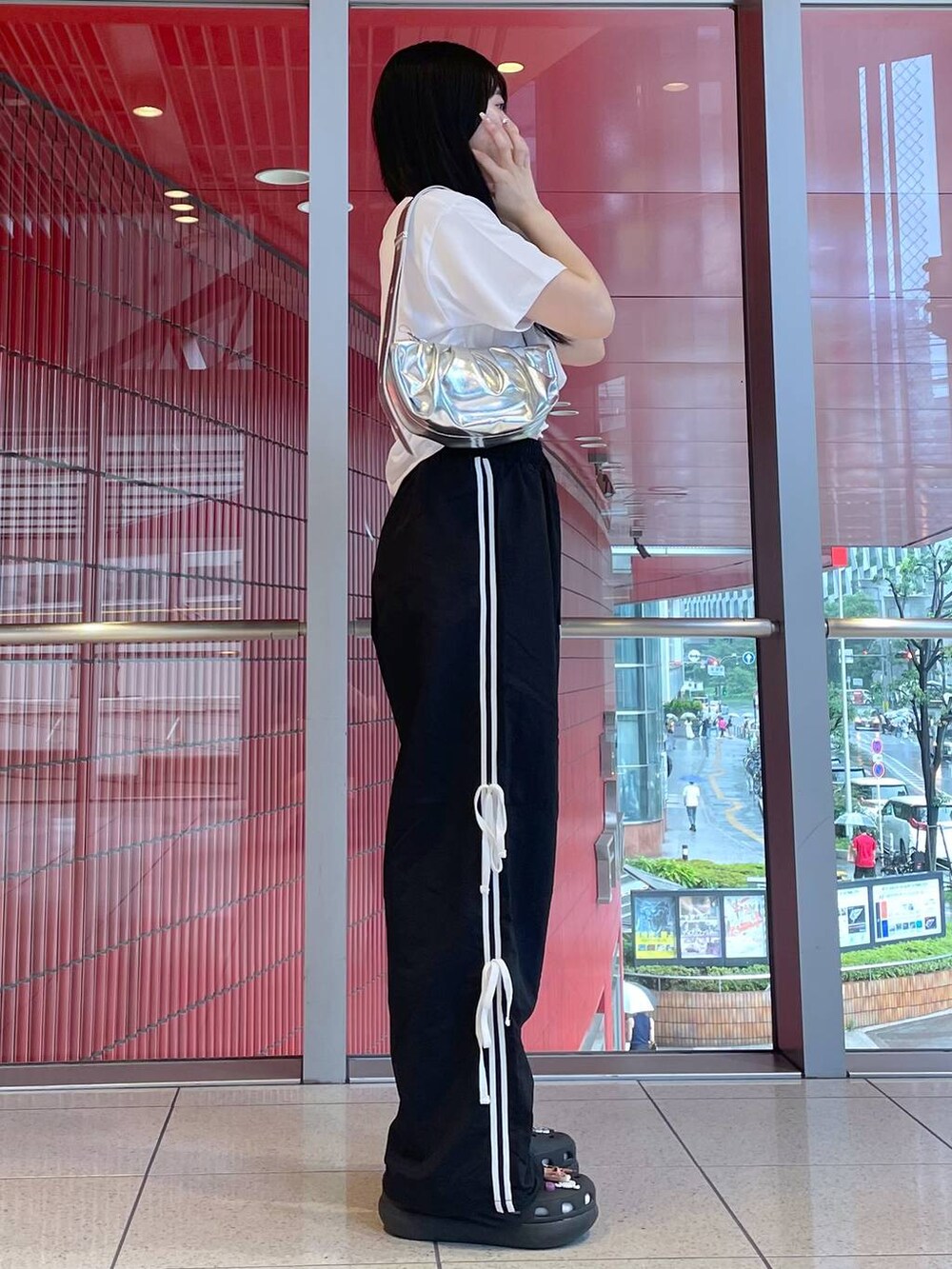 グレー系のトートバッグ、ブラック系のサンダル、ホワイト系のTシャツ/カットソーを着用したレディースの夏コーディネートの2枚目の写真