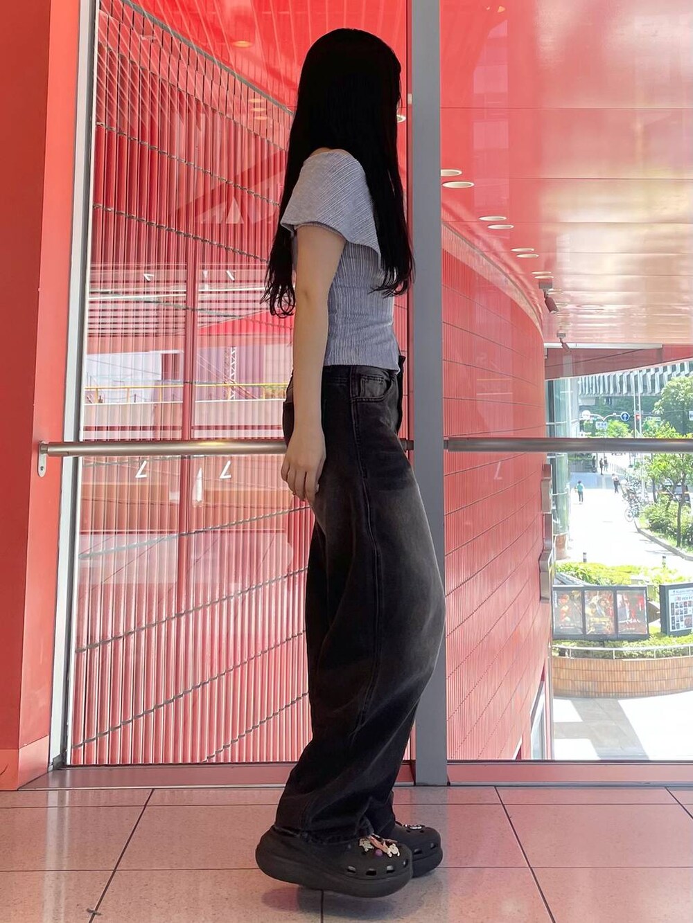 ブラック系のデニムパンツ、ブラック系のサンダル、パープル系のTシャツ/カットソーを着用したレディースの夏コーディネートの2枚目の写真