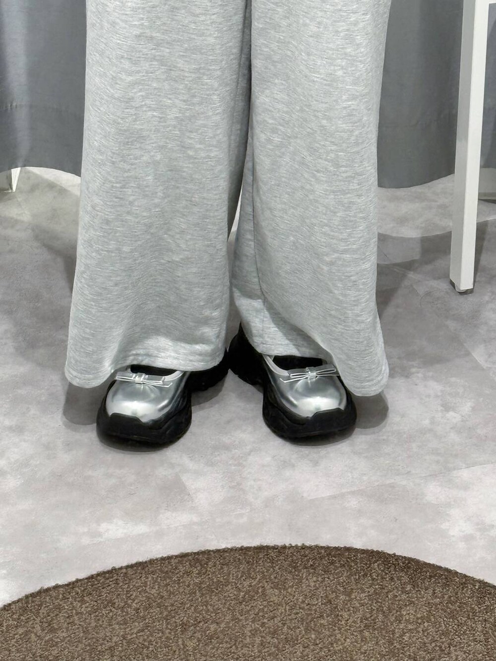 シルバー系のパンプス、グレー系のスウェットパンツを着用したレディースの夏コーディネートの3枚目の写真