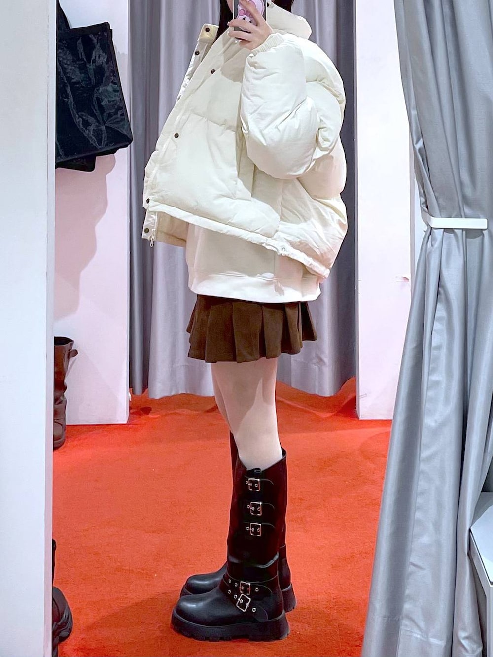 ベージュ系のダウンジャケット/コート、ブラック系のブーツ、ベージュ系のスウェットを着用したレディースの冬コーディネートの4枚目の写真