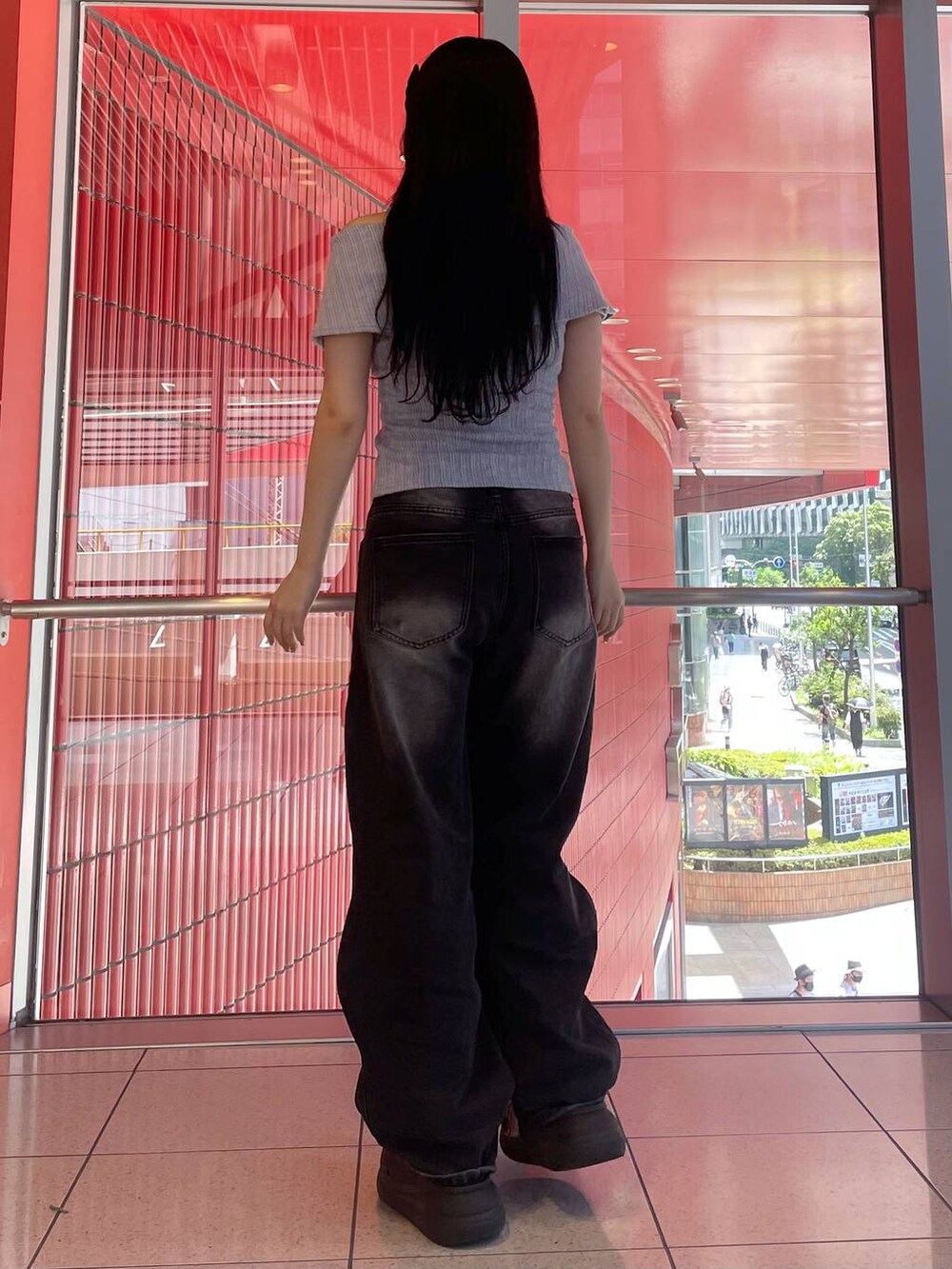 ブラック系のデニムパンツ、ブラック系のサンダル、パープル系のTシャツ/カットソーを着用したレディースの夏コーディネートの3枚目の写真