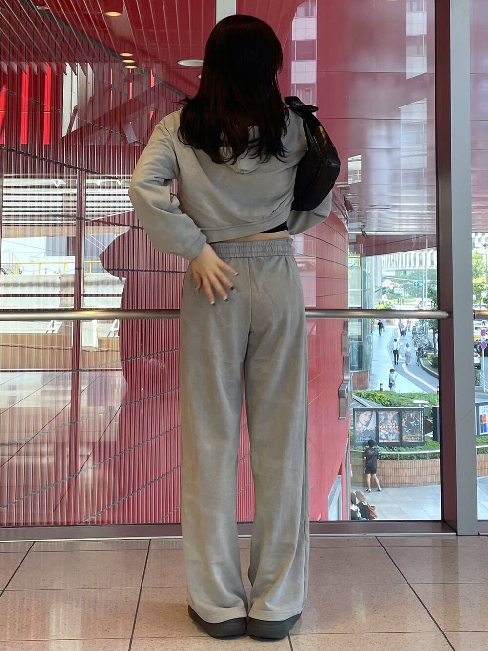 ブラック系のサンダル、グレー系のパーカー、ブラック系のハンドバッグを着用したレディースの秋コーディネートの3枚目の写真